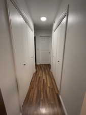 Hallway featuring dark wood-style floors and baseboards