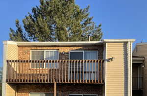 View of front facade with brick siding and a balcony