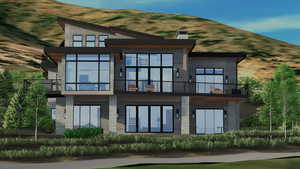 Rear view of house featuring a balcony and stone siding