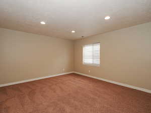 Carpeted spare room featuring baseboards and recessed lighting