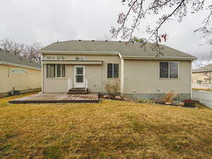 Back of house with stucco siding and a deck