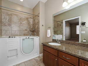 Full bathroom featuring vanity, light tile patterned floors, and bathing tub / shower combination