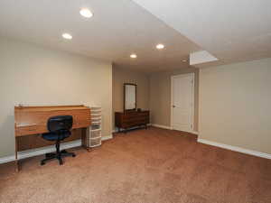 Office with light carpet and recessed lighting