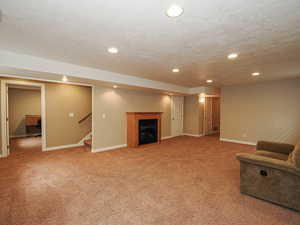 Unfurnished living room with recessed lighting, light colored carpet, and a fireplace