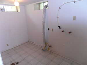 Basement with light flooring and baseboards
