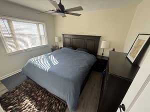 Bedroom with dark wood-style flooring and ceiling fan