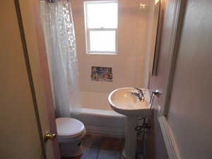 Full bathroom featuring shower / bathtub combination with curtain and tile patterned flooring
