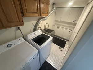Laundry area featuring cabinet space and separate washer and dryer