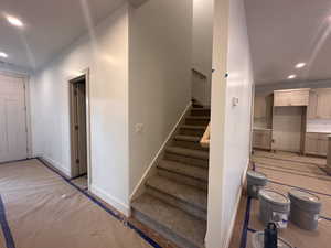 Stairs with recessed lighting and baseboards