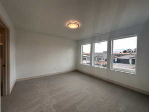 Empty room featuring carpet and baseboards