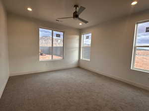 Carpeted spare room with a ceiling fan, recessed lighting, and a mountain view