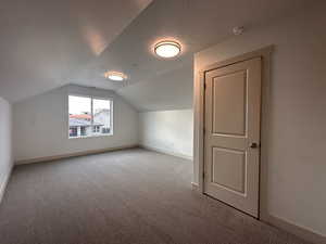 Additional living space featuring light colored carpet and a textured ceiling