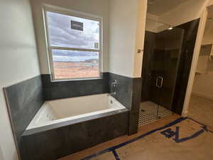 Full bath with a garden tub, a stall shower, and a walk in closet