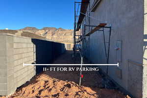 View of side of home with a mountain view, stucco siding, and stairs