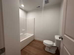 Bathroom featuring wood finished floors, bathing tub / shower combination, and recessed lighting