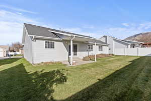 Rear view of property with a patio area, a shingled roof, a mountain view, and entry steps