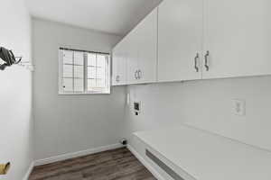 Laundry area with washer hookup, dark wood-type flooring, and cabinet space
