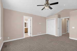 Spacious room featuring vaulted ceilings, neutral-toned walls, and plush carpet flooring