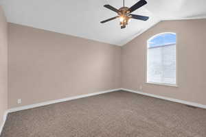Interior room featuring a vaulted ceiling and a large arched window with blinds