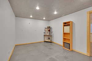 Misc room featuring finished concrete floors, a textured ceiling, and recessed lighting