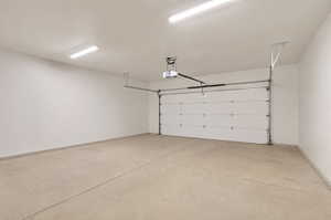 Spacious garage featuring a concrete floor, white walls, and bright overhead lighting