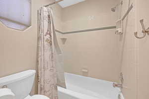 Full bathroom with shower / bath combo and toilet