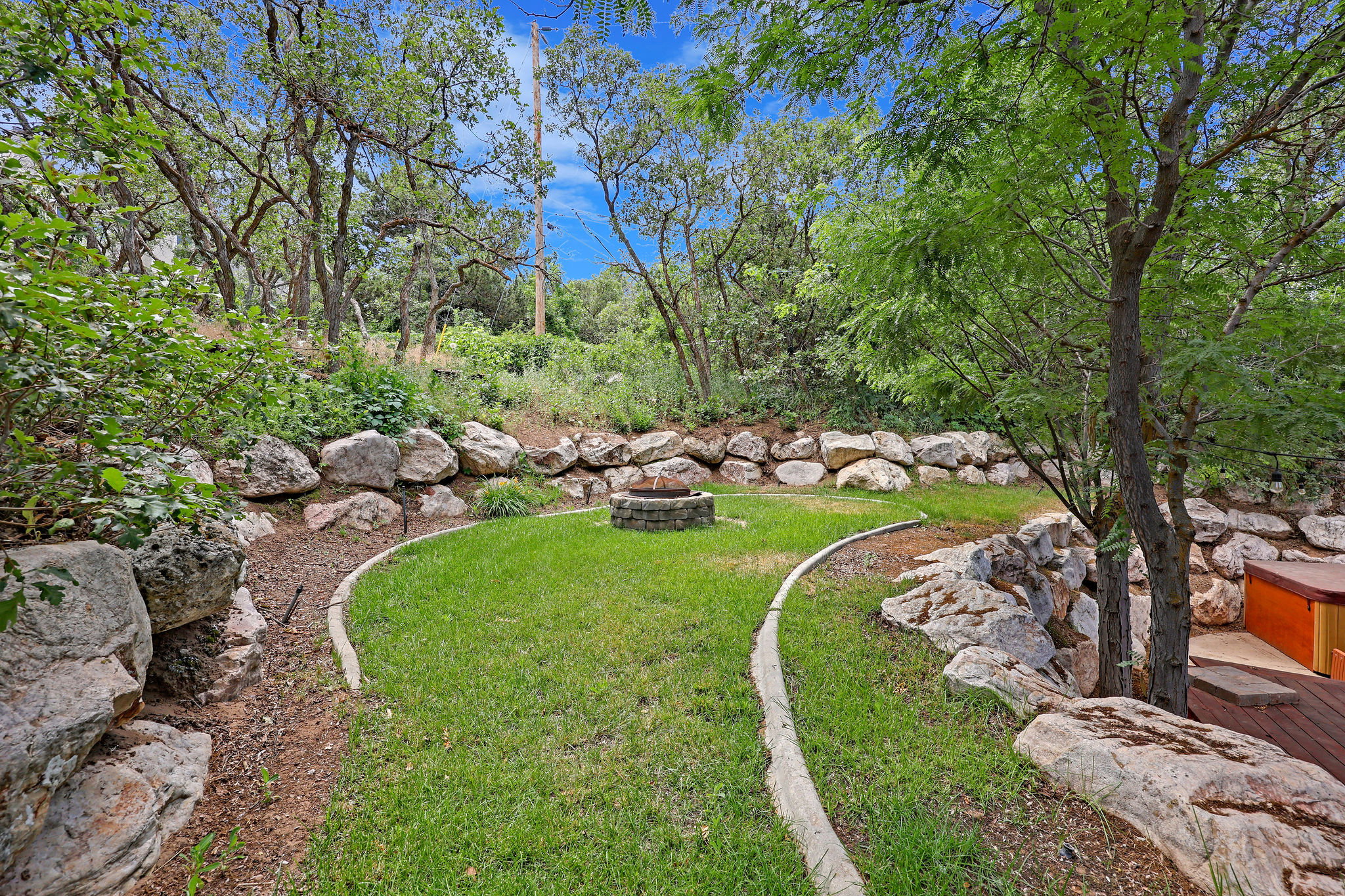 View of green lawn featuring a fire pit