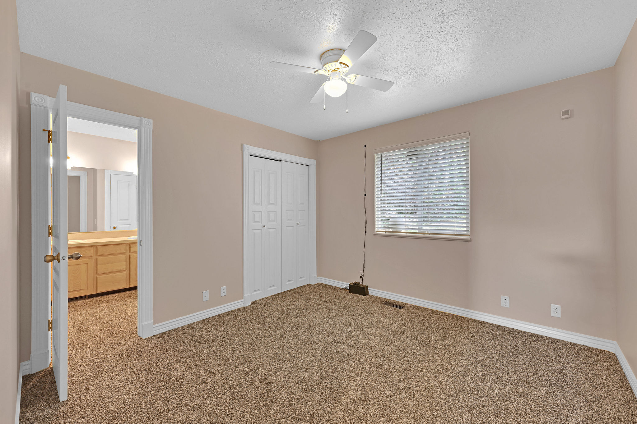 Unfurnished bedroom featuring carpet flooring, a textured ceiling, a closet, and ceiling fan