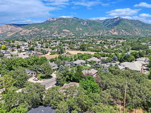 Aerial view of residential area featuring mountains and a tree filled landscape