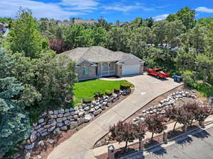 View of front facade with a front yard, driveway, an attached garage, stucco siding, and brick siding