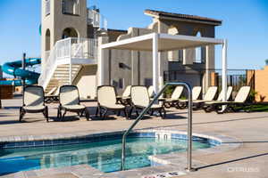 View of swimming pool featuring a swimming pool, a patio, stairway, and a community hot tub