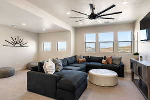 Living area with light carpet, a textured ceiling, ceiling fan, and recessed lighting