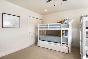 Bedroom featuring light colored carpet, a closet, recessed lighting, a ceiling fan, and a textured ceiling