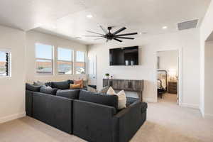 Living room with light colored carpet, a textured ceiling, recessed lighting, and a ceiling fan