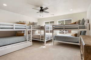 Carpeted bedroom with a textured ceiling, ceiling fan, and recessed lighting
