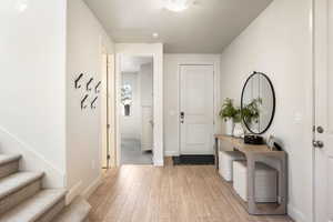 Entrance foyer featuring light wood-style floors and a textured ceiling