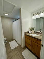 Bathroom featuring a shower with curtain, vanity, and light tile patterned flooring