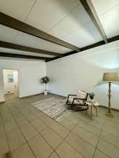 Unfurnished room with tile patterned floors and beamed ceiling