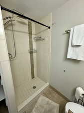 Full bathroom with a stall shower and tile patterned flooring