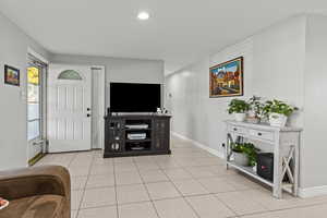 Living area featuring light tile patterned flooring and recessed lighting