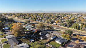 Aerial view of property and surrounding area with nearby suburban area and mountains