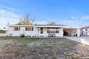 View of front of home featuring a patio area, a carport, and driveway