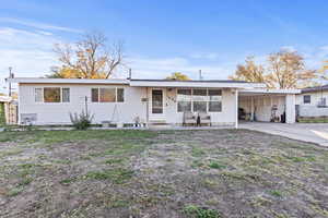 Single story home featuring an attached carport, concrete driveway, and a patio
