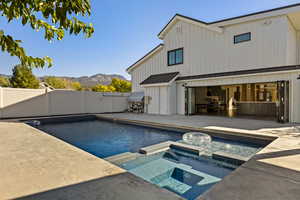 View of swimming pool with a mountain view, a patio, a pool with connected hot tub, and a fenced backyard