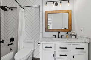 Full bath featuring shower / bath combo with shower curtain and vanity