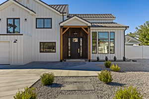 Property entrance featuring a metal roof, a standing seam roof, and board and batten siding