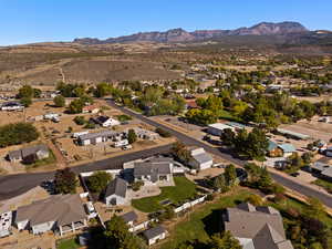 Aerial view of property and surrounding area featuring nearby suburban area