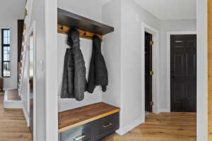 Mudroom featuring light wood-type flooring and baseboards