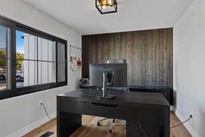 Office space with wooden walls, light wood-style floors, and a textured ceiling