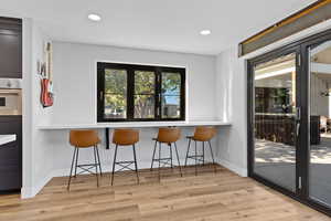 Dining area with light wood-style floors and recessed lighting